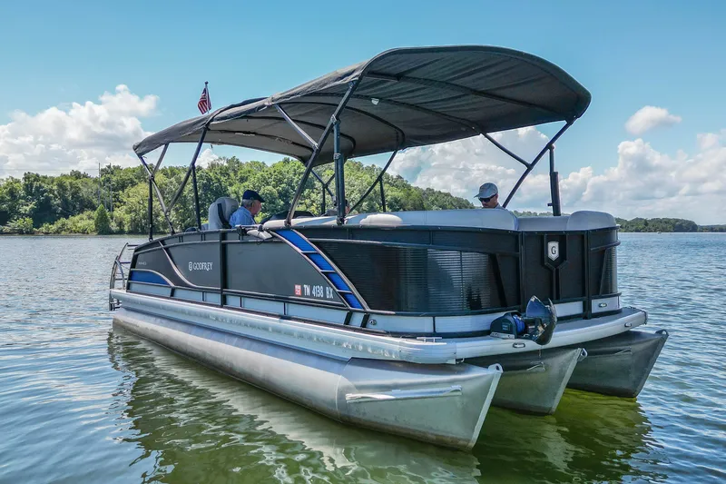 Slide: The Image of 2021 Godfrey Monaco 235 pontoon boat cruising on a serene lake. - 3