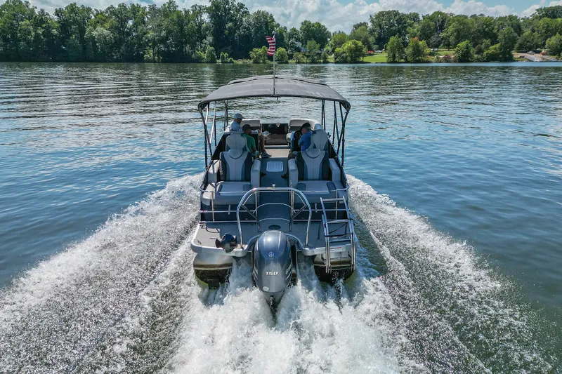 Slide: The Image of 2021 Godfrey Monaco 235 pontoon boat cruising on a serene lake. - 13