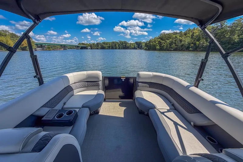 Slide: The Image of 2021 Godfrey Monaco 235 pontoon boat interior on a scenic lake with blue sky. - 19