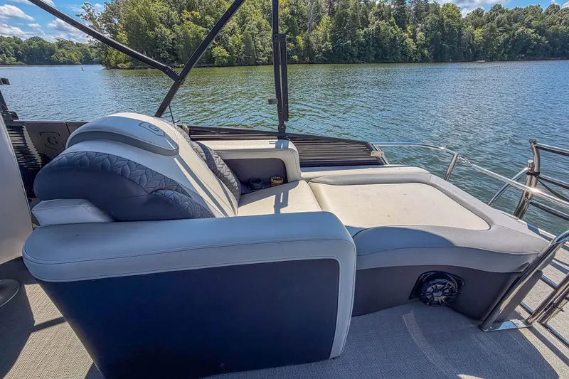Slide: The Image of Luxurious seating on 2021 Godfrey Monaco 235 boat, overlooking serene lake and lush trees. - 28