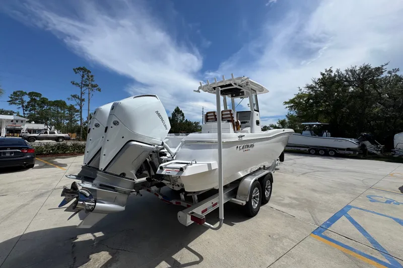 Slide: The Image of 2027 Caymas 291 boat with dual Mercury engines on a trailer, parked outdoors. - 13