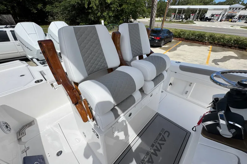 Slide: The Image of Luxury seating on 2027 Caymas 291 boat with quilted upholstery and wooden armrests. - 31