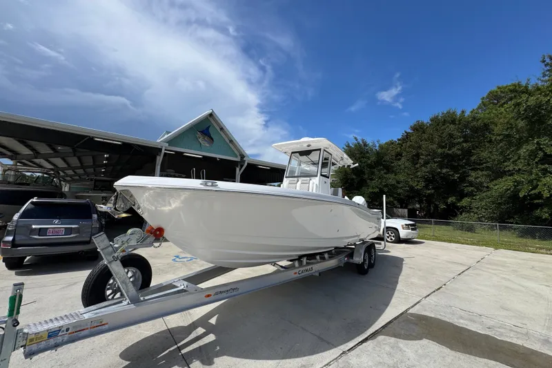 Slide: The Image of 2027 Caymas 291 boat on trailer, parked outdoors under a clear blue sky. - 4