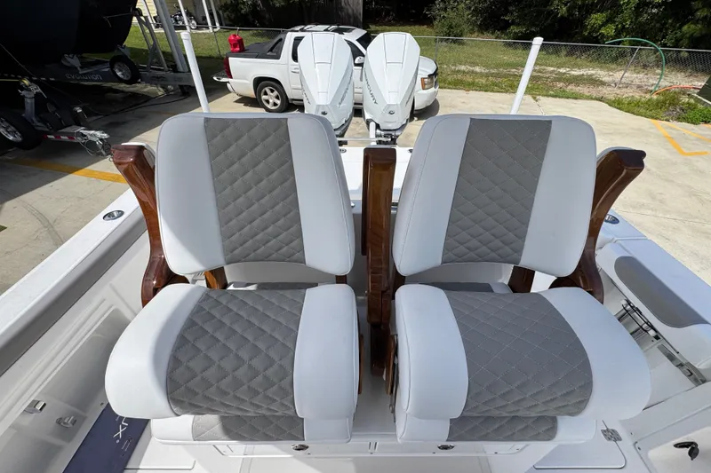 Slide: The Image of Luxury seating on 2027 Caymas 291 boat, featuring quilted upholstery and wooden armrests. - 29