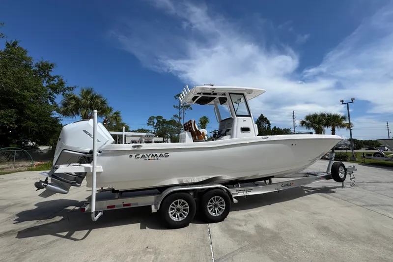 Slide: The Image of 2027 Caymas 291 boat on trailer under clear blue sky, showcasing sleek design and powerful engine. - 11