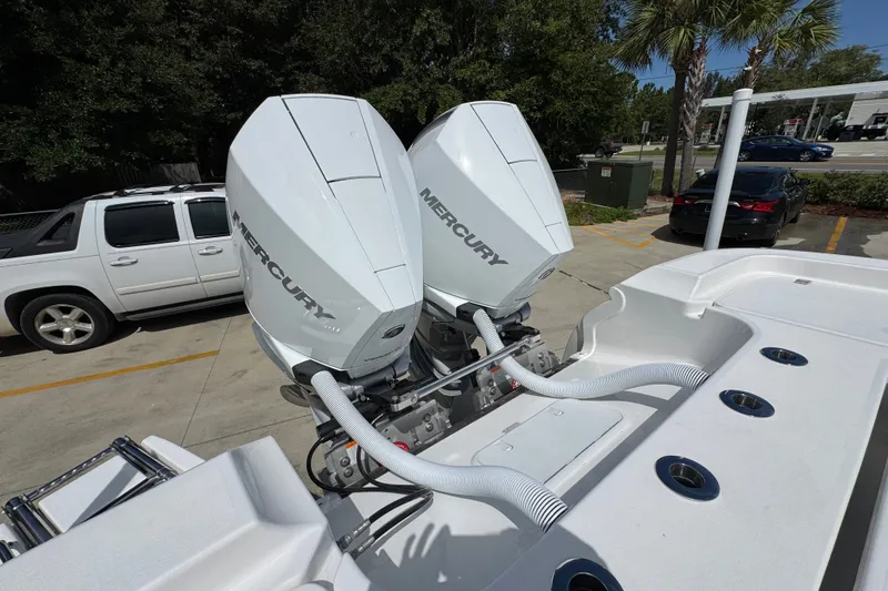 Slide: The Image of Twin Mercury outboard engines on a 2027 Caymas 291 boat, parked outdoors. - 44
