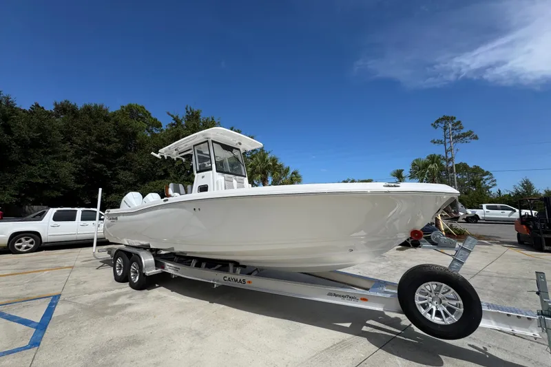 Slide: The Image of 2027 Caymas 291 boat on trailer, parked outdoors under clear blue sky. - 8