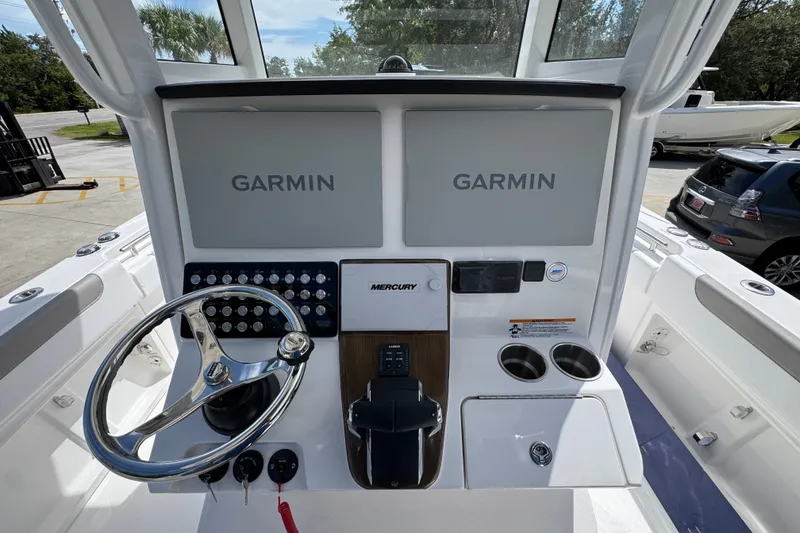 Slide: The Image of 2027 Caymas 291 boat dashboard with dual Garmin displays and Mercury controls. - 33