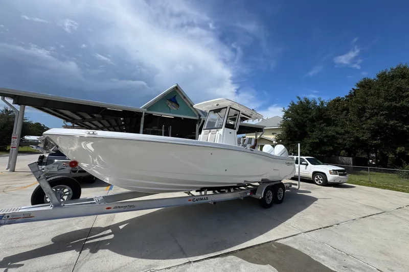 Slide: The Image of 2027 Caymas 291 boat on trailer under blue sky at marina. - 3