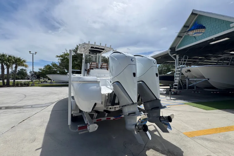Slide: The Image of 2027 Caymas 291 boat with dual outboard motors in a marina setting. - 16