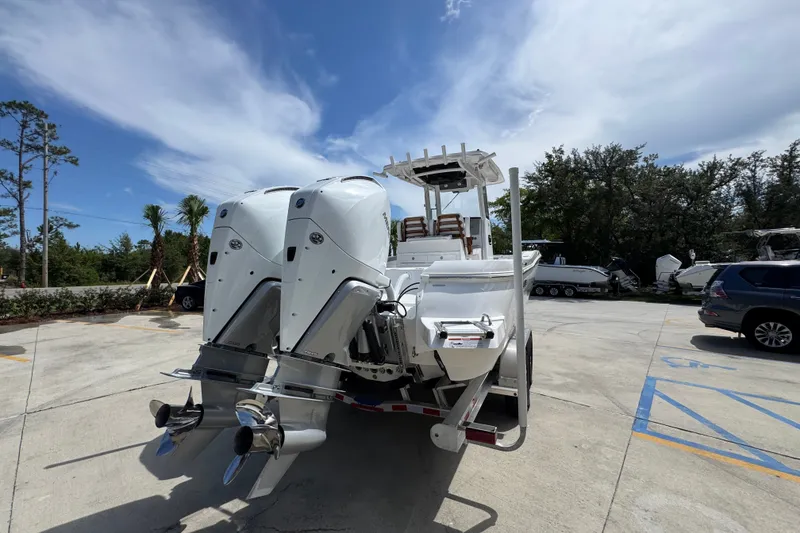 Slide: The Image of 2027 Caymas 291 boat with dual outboard motors in a parking lot. - 14