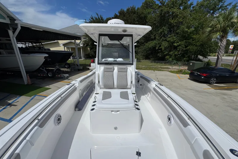 Slide: The Image of 2027 Caymas 291 boat with sleek design, spacious seating, and modern features, docked outdoors. - 24