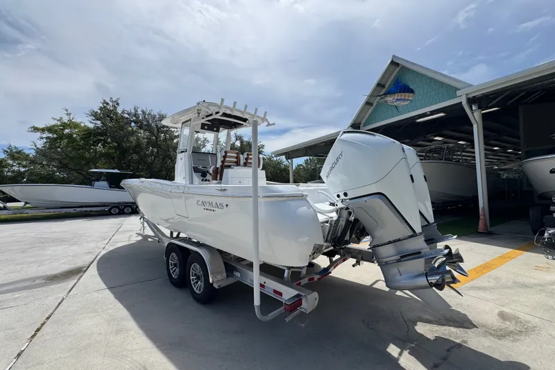 Slide: The Image of 2027 Caymas 291 boat on trailer with dual Mercury engines, parked outdoors. - 17