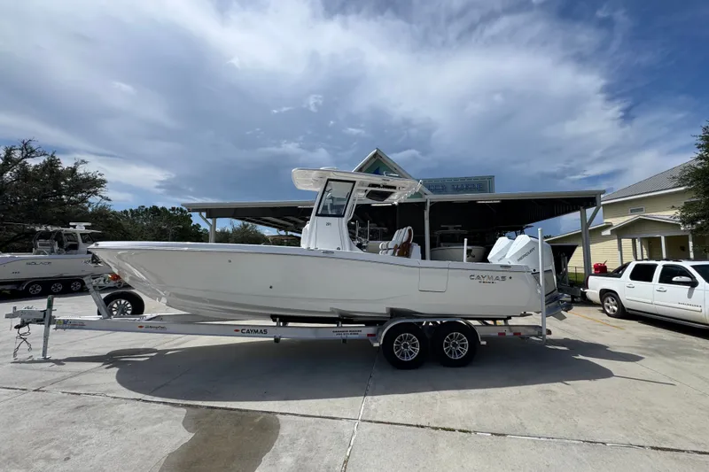 The Image of 2027 Caymas 291 boat on trailer, parked outdoors under a cloudy sky. - 1