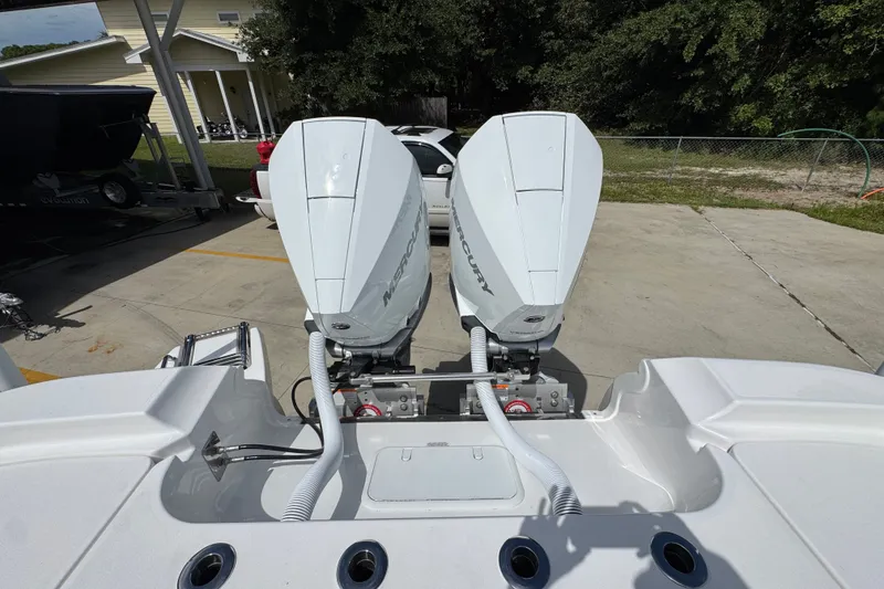 Slide: The Image of Twin Mercury outboard engines on a 2027 Caymas 291 boat, parked outdoors. - 42