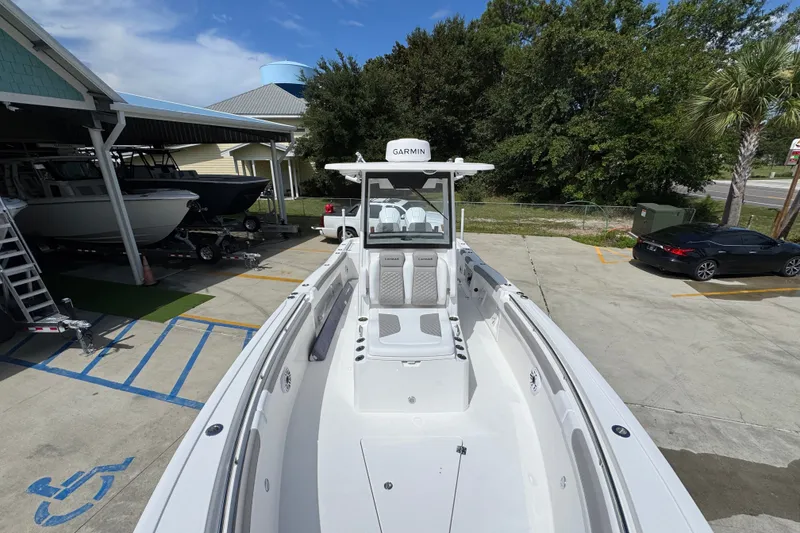 Slide: The Image of 2027 Caymas 291 boat with Garmin equipment, parked outdoors near other boats and vehicles. - 23