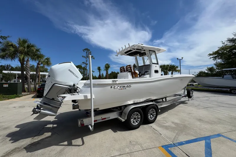 Slide: The Image of 2027 Caymas 291 boat on trailer, parked outdoors under a clear blue sky. - 12