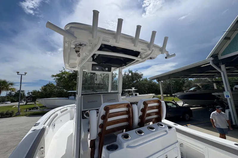 Slide: The Image of 2027 Caymas 291 boat interior with Garmin electronics and rod holders under a clear sky. - 38