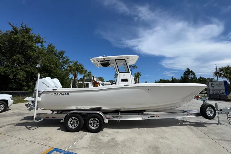 Slide: The Image of 2027 Caymas 291 boat on trailer under clear blue sky, parked outdoors. - 10