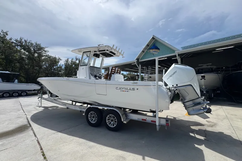 Slide: The Image of 2027 Caymas 291 boat on trailer with Mercury outboard engine, parked outdoors. - 18