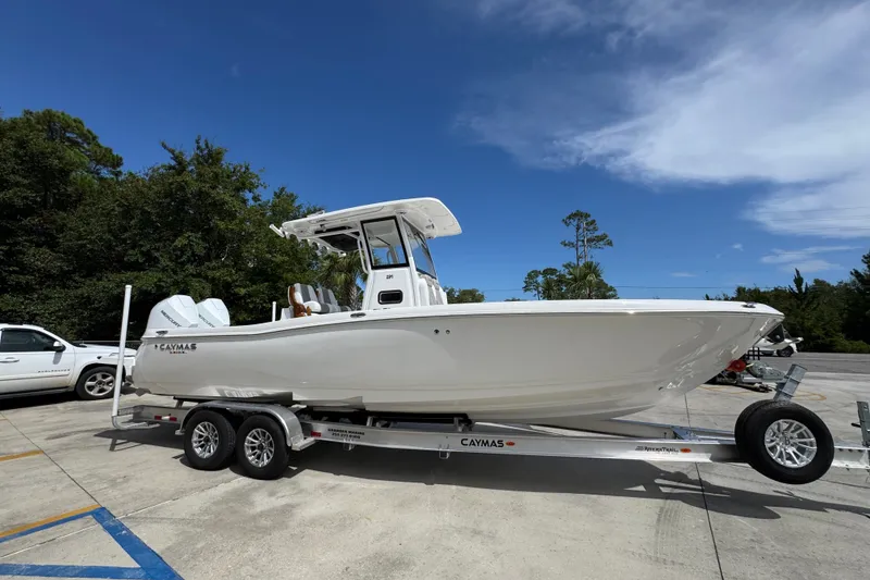 Slide: The Image of 2027 Caymas 291 boat on trailer, parked outdoors under clear blue sky. - 9