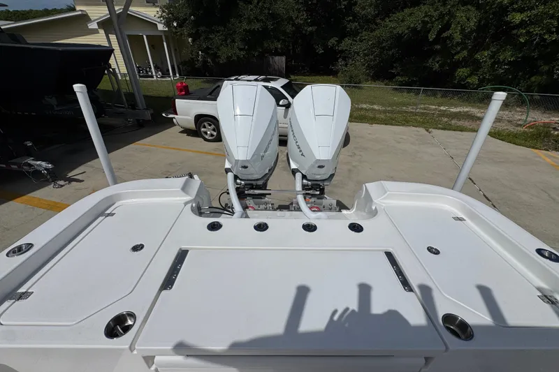 Slide: The Image of 2027 Caymas 291 boat with dual outboard motors, parked on a concrete driveway. - 40