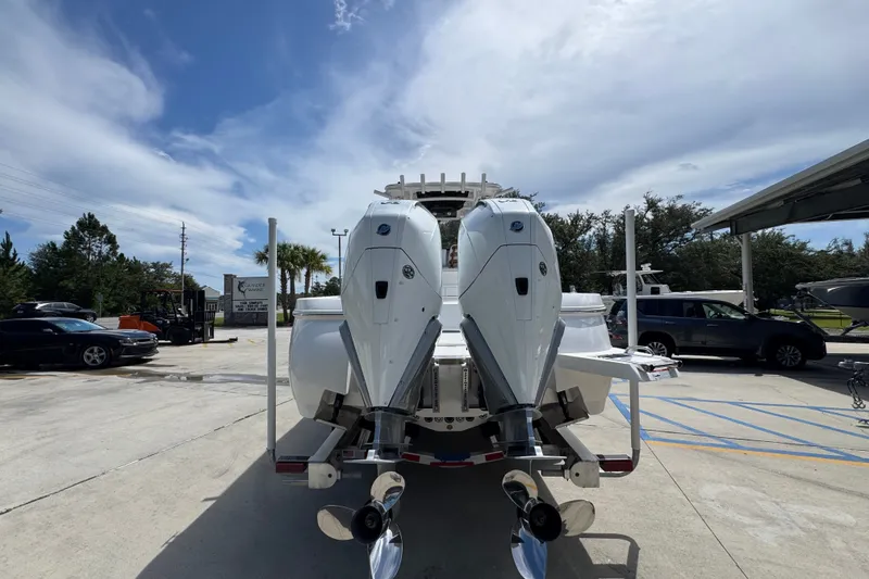 Slide: The Image of 2027 Caymas 291 boat with dual outboard motors in a parking lot. - 15