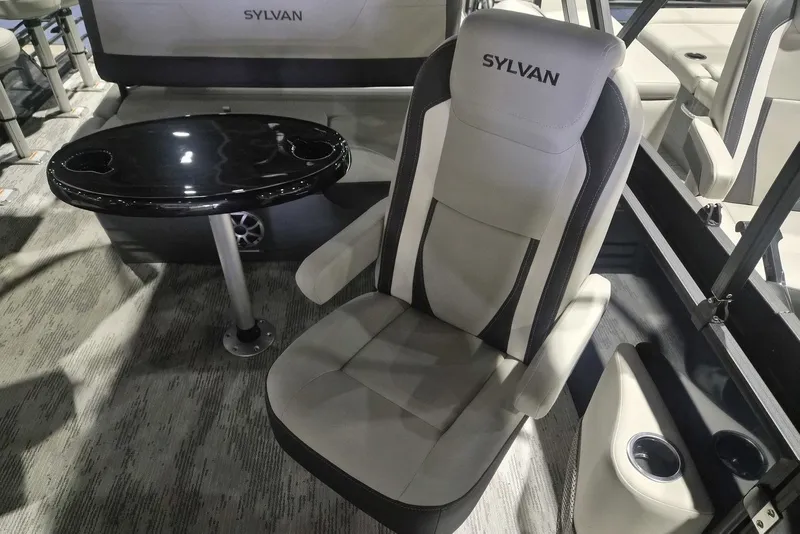 Slide: The Image of 2026 Sylvan X3 DLZ DH BAR boat interior with plush seating and sleek black table. - 9