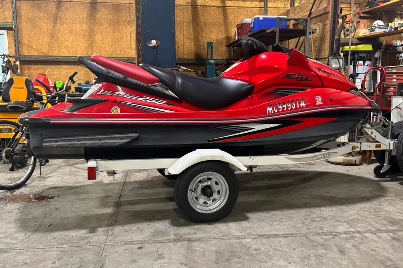 The Image of 2007 Kawasaki Jet Ski Ultra 250X in a garage, mounted on a trailer. - 0