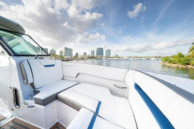 Slide: The Image of 2027 Tiara Yachts 34 LX interior with waterfront cityscape view, featuring luxurious seating. - 14