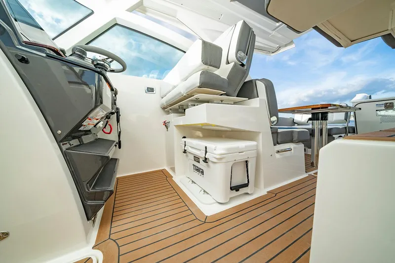 Slide: The Image of 2027 Tiara Yachts 34 LX interior with modern helm, seating, and wooden flooring. - 13