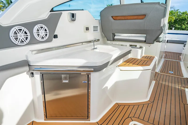 Slide: The Image of 2027 Tiara Yachts 34 LX interior with sleek design, featuring a kitchenette and seating area. - 16