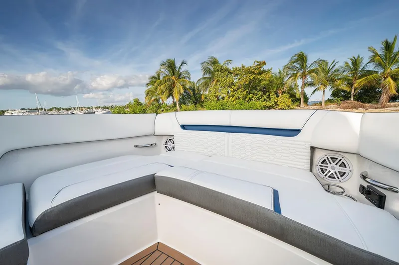 Slide: The Image of 2027 Tiara Yachts 34 LX interior with white seating, palm trees, and blue sky background. - 15