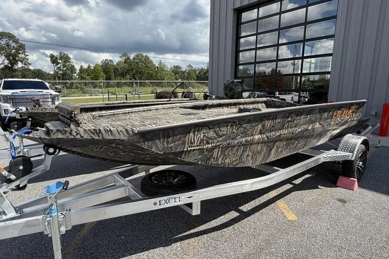 Slide: The Image of 2027 Excel 1751 Viper F4 boat on trailer, camo design, parked outdoors. - 21