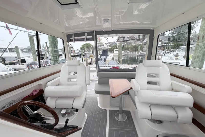 Slide: The Image of Interior of 2023 NorthCoast 285 Cabin boat with plush seating and wooden accents. - 18