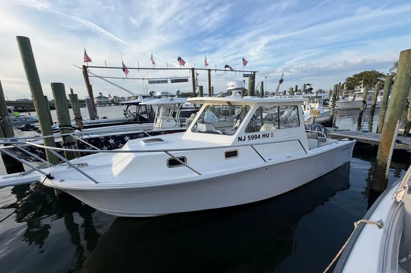 The Image of 2023 NorthCoast 285 Cabin boat docked at a marina under a partly cloudy sky. - 0
