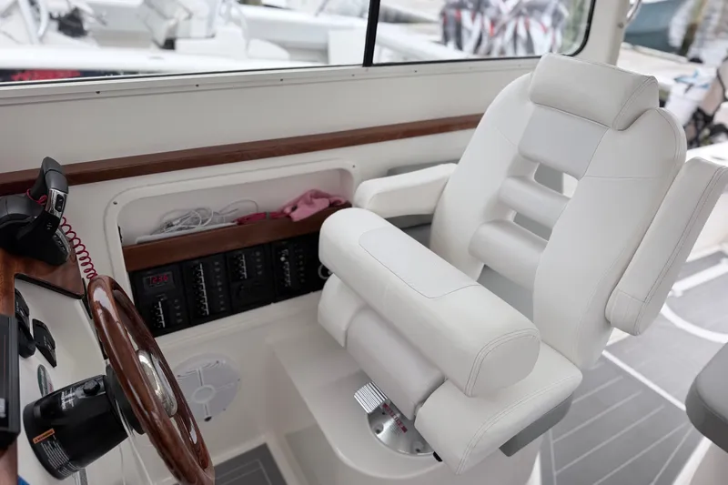 Slide: The Image of 2023 NorthCoast 285 Cabin interior with white captain's chair and control panel. - 15