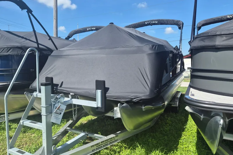 The Image of 2027 Sylvan R-22 LZ DH pontoon boat covered on trailer, sunny day. - 1