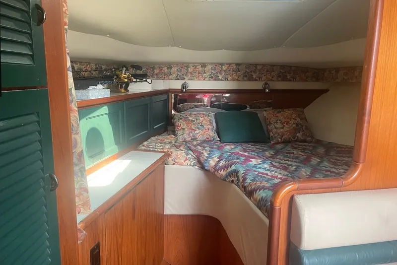 Slide: The Image of Cozy cabin interior of 1997 Pursuit 3400 Express with floral decor and wooden accents. - 15