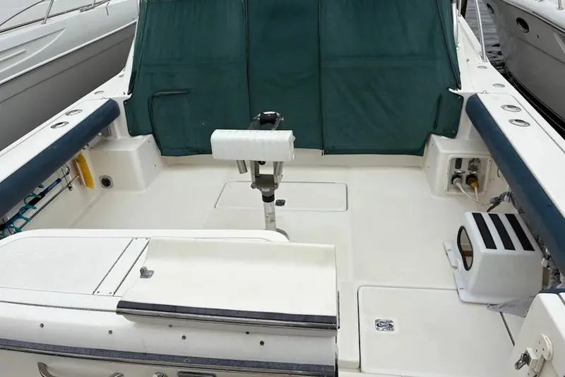Slide: The Image of 1997 Pursuit 3400 Express boat deck with seating and fishing equipment. - 9