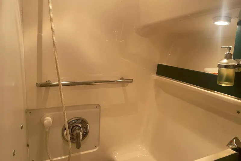 Slide: The Image of Interior of 1997 Pursuit 3400 Express boat bathroom with shower and soap dispenser. - 21