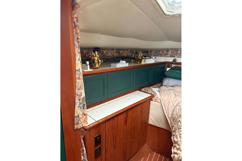 Slide: The Image of Interior cabin of a 1997 Pursuit 3400 Express boat with wood paneling and floral accents. - 19