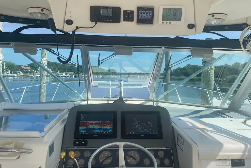 Slide: The Image of Cockpit view of a 1997 Pursuit 3400 Express boat with navigation screens. - 10