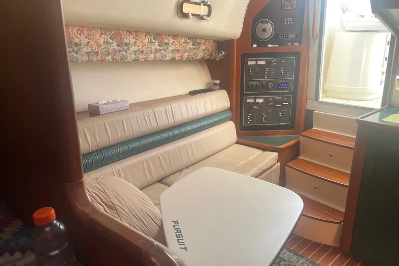 Slide: The Image of Interior of a 1997 Pursuit 3400 Express boat with seating and control panel. - 17