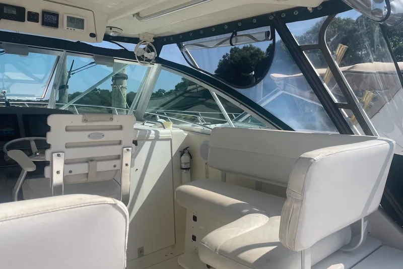 Slide: The Image of Interior of a 1997 Pursuit 3400 Express boat with white seating and dashboard. - 13