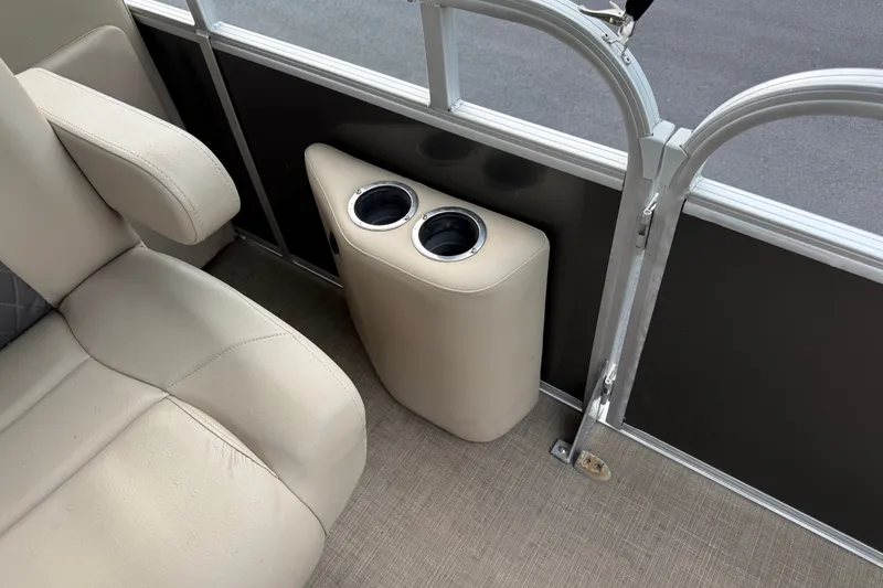 Slide: The Image of 2023 Sun Tracker Party Barge 22 XP3 interior with beige seating and dual cup holders. - 31