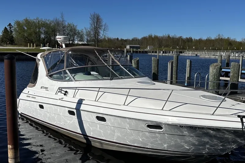 The Image of 1997 Cruisers Yachts 337 Esprit docked at a marina under clear blue skies. - 0
