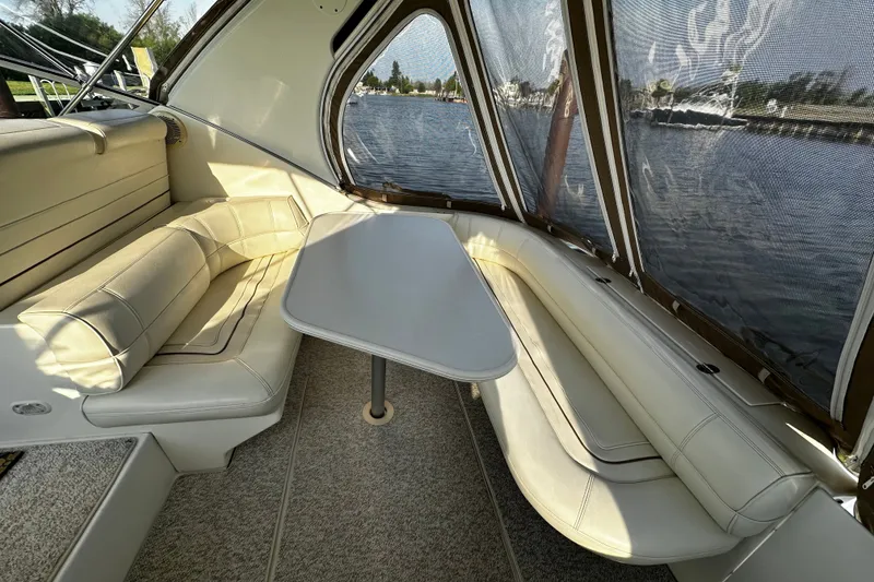 Slide: The Image of Interior of 1997 Cruisers Yachts 337 Esprit with elegant seating and table by the water. - 3