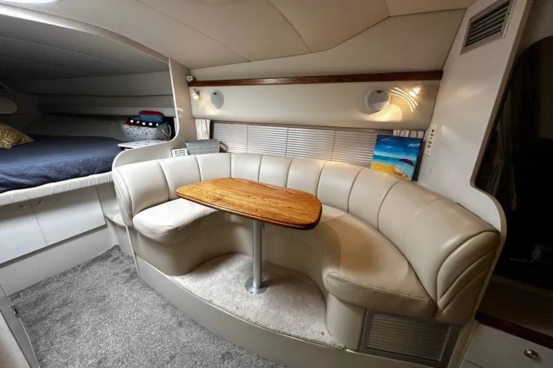 Slide: The Image of 1997 Cruisers Yachts 337 Esprit interior with curved seating and wooden table. - 10
