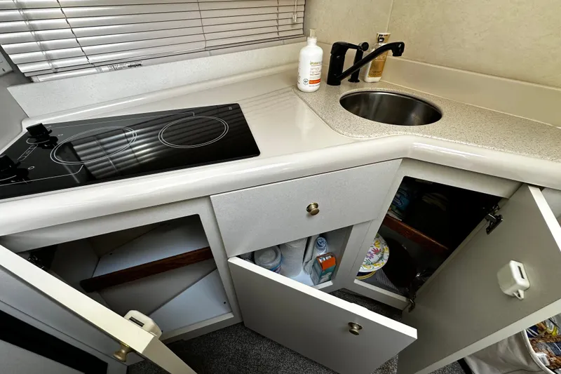 Slide: The Image of 1997 Cruisers Yachts 337 Esprit kitchen with stove, sink, and open cabinets. - 19